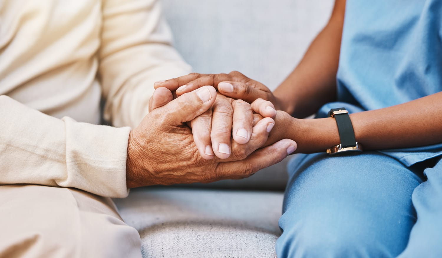 Hände einer Pflegekraft halten die Hände einer Patientin